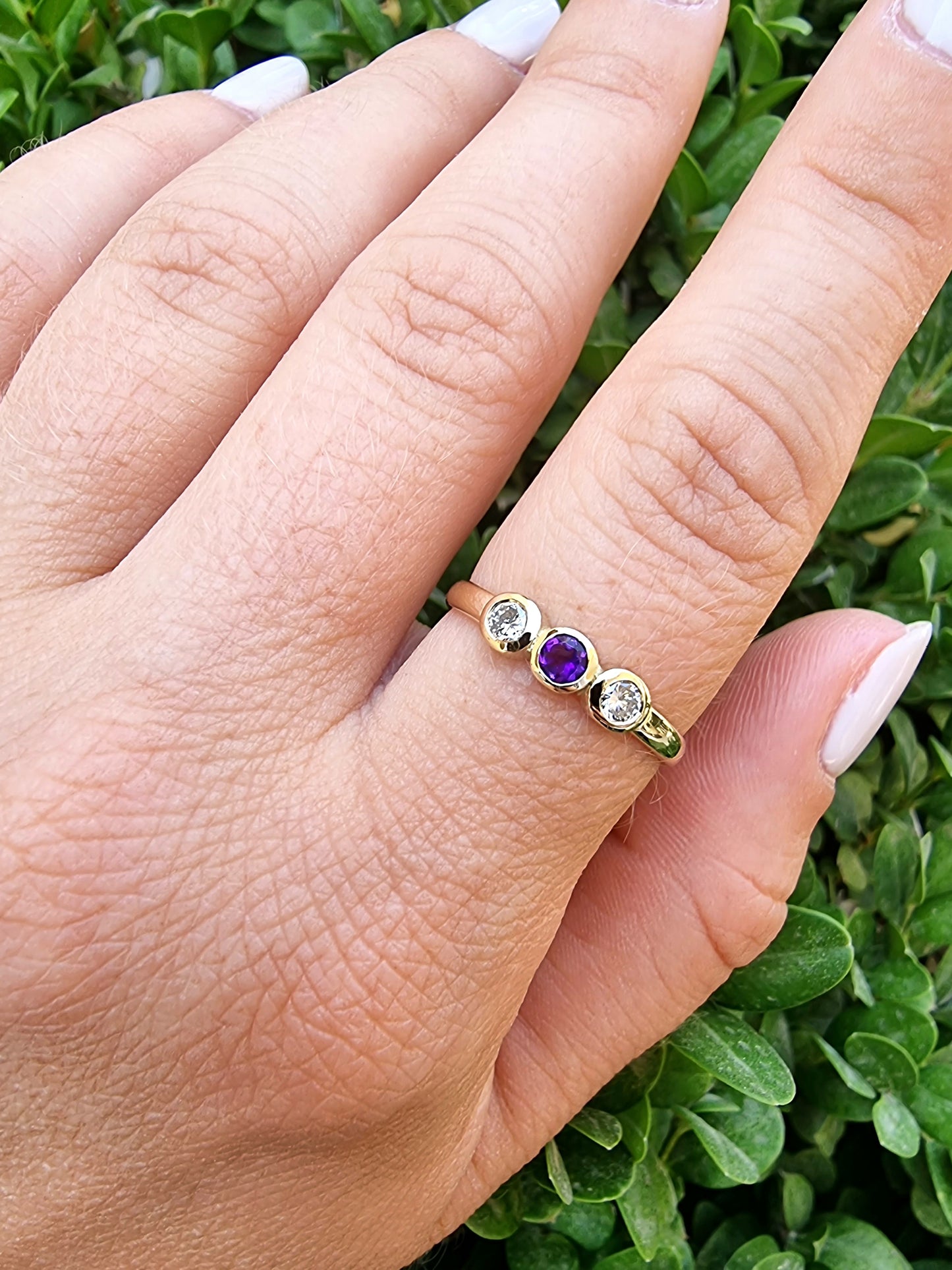 A handmade ring featuring three birthstones set in a bezel, crafted in 14k solid gold.