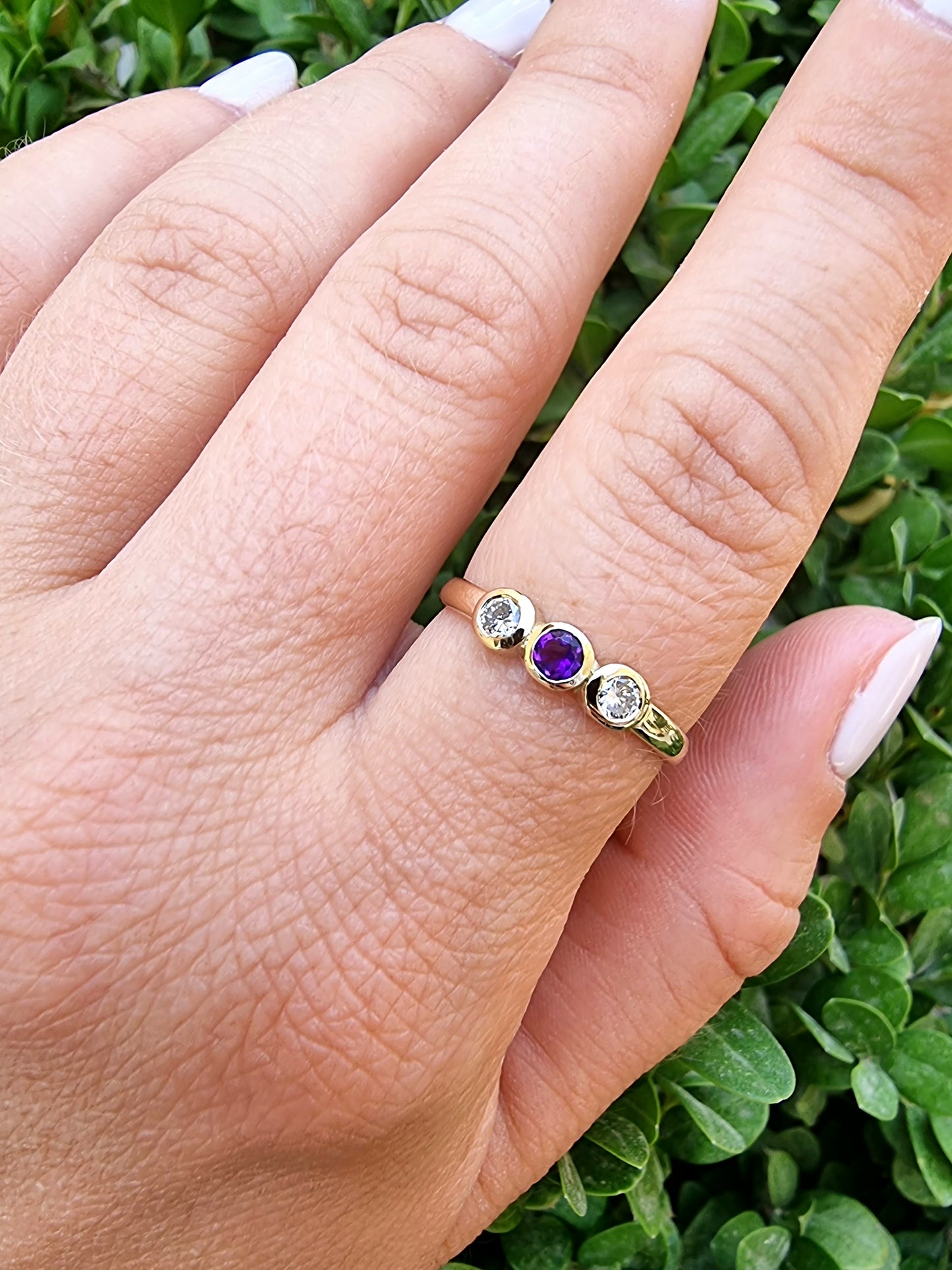 A handmade ring featuring three birthstones set in a bezel, crafted in 14k solid gold.
