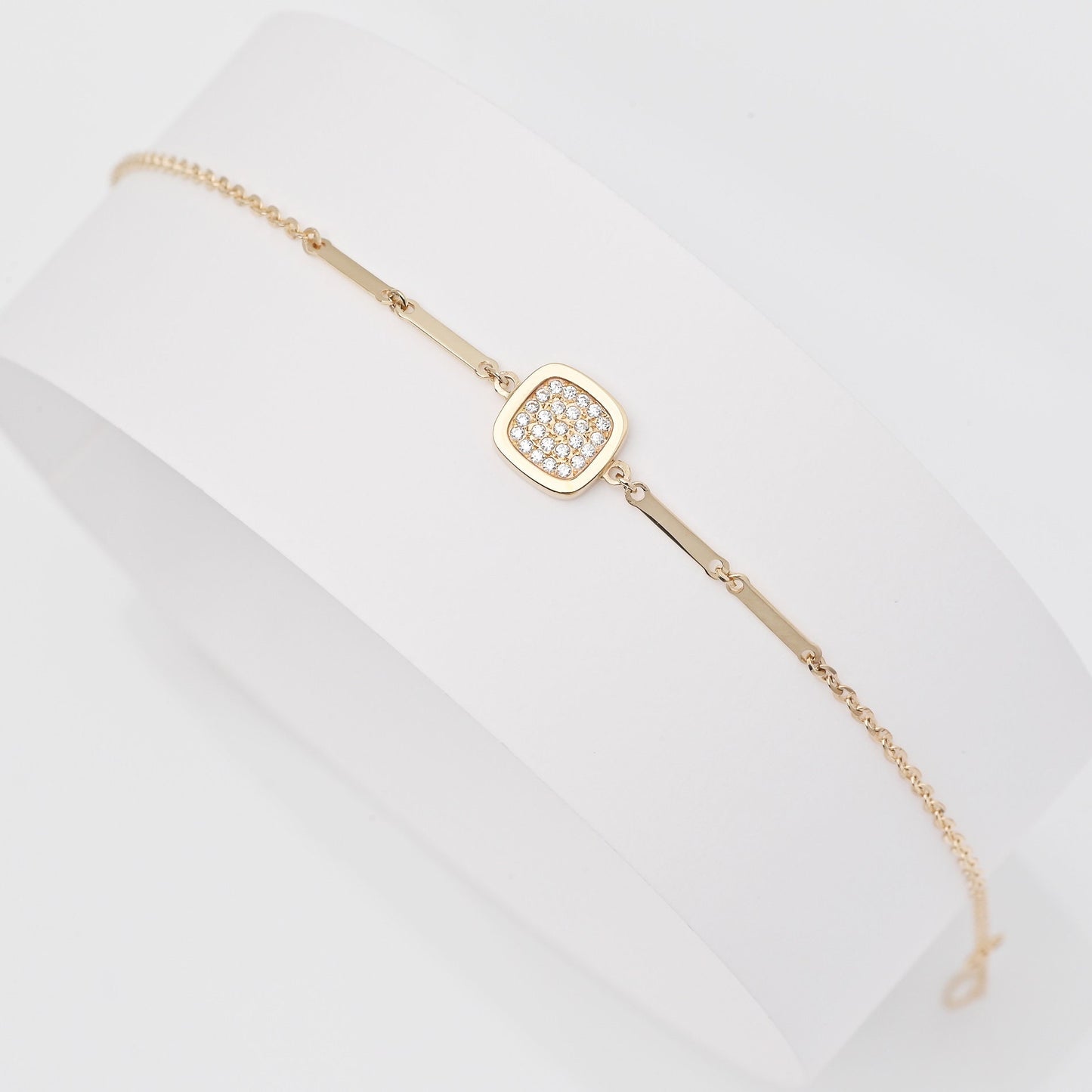 a 14k gold charm bracelet with a square charm paved with white cubic zirconia stones