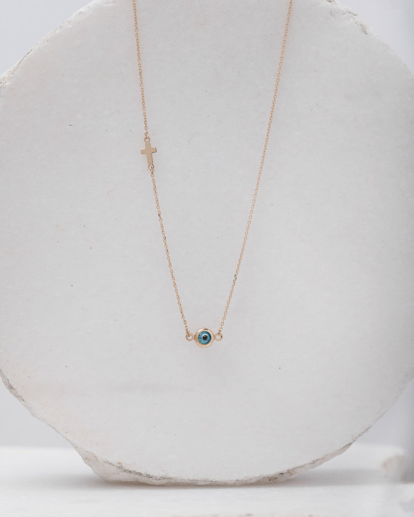Murano glass double-sided evil eye necklace in 14k gold with a small side cross.