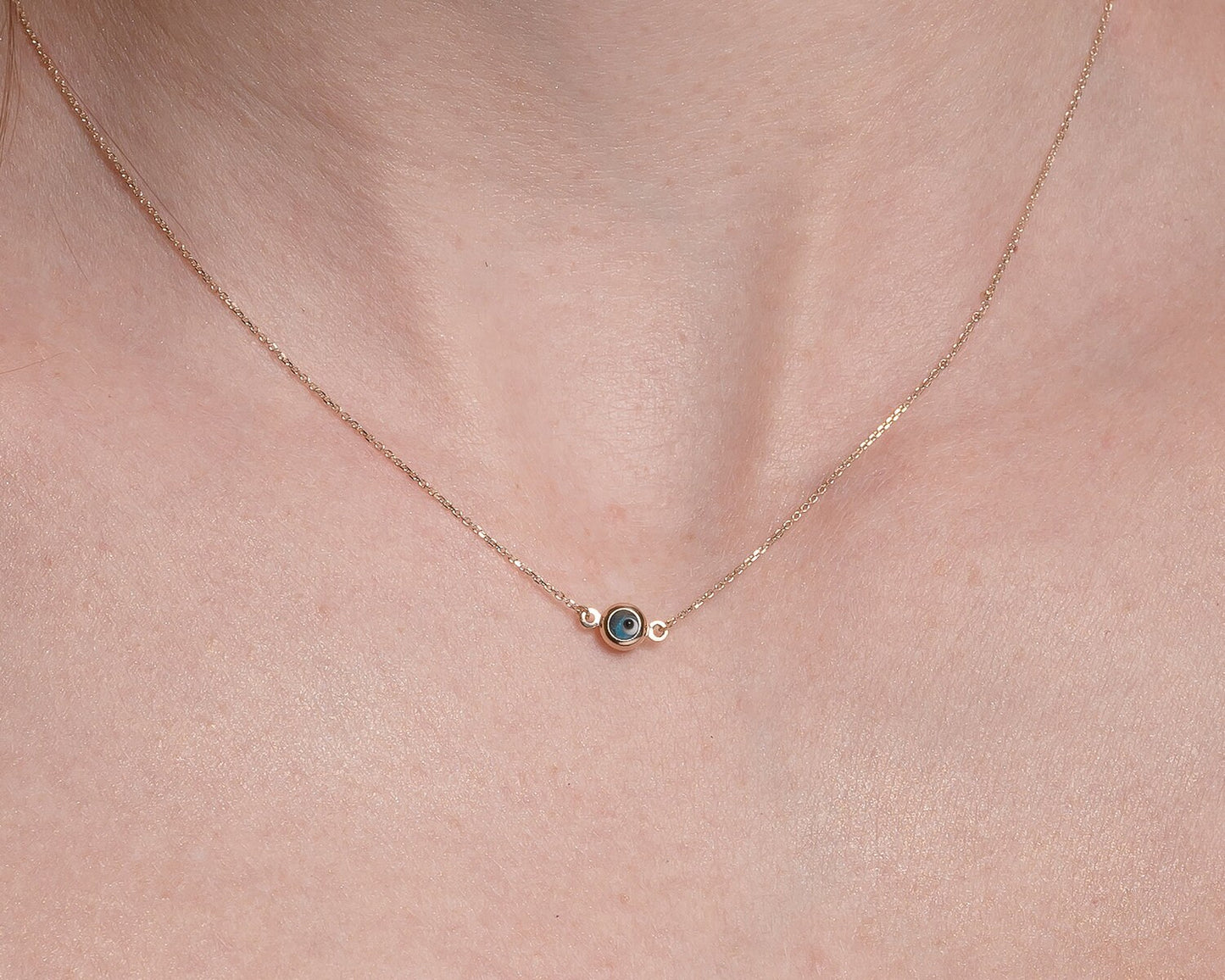 Murano glass double-sided evil eye necklace in 14k gold worn by a model