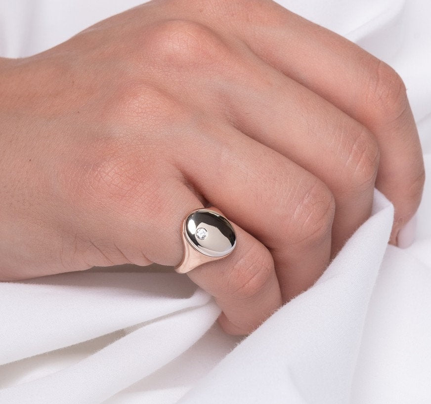 Oval diamond signet rings in 14k yellow gold for women worn by a model