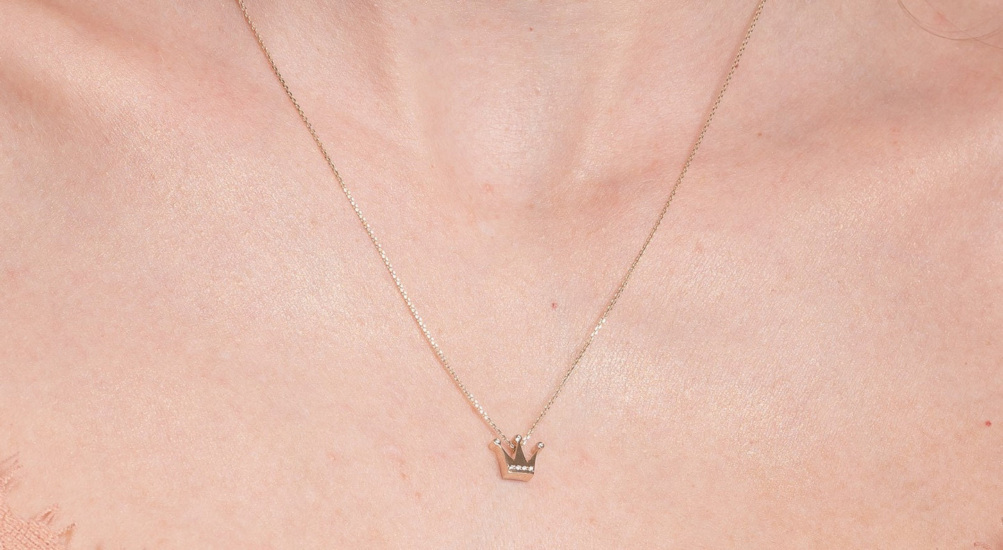 crown necklace in 14k yellow gold with cubic zirconia stones worn by a model