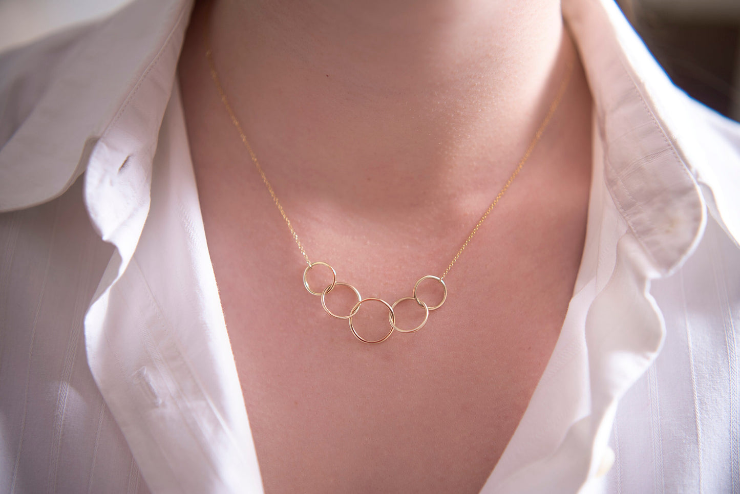 14k gold necklace with five interlocking circles for women worn by a model