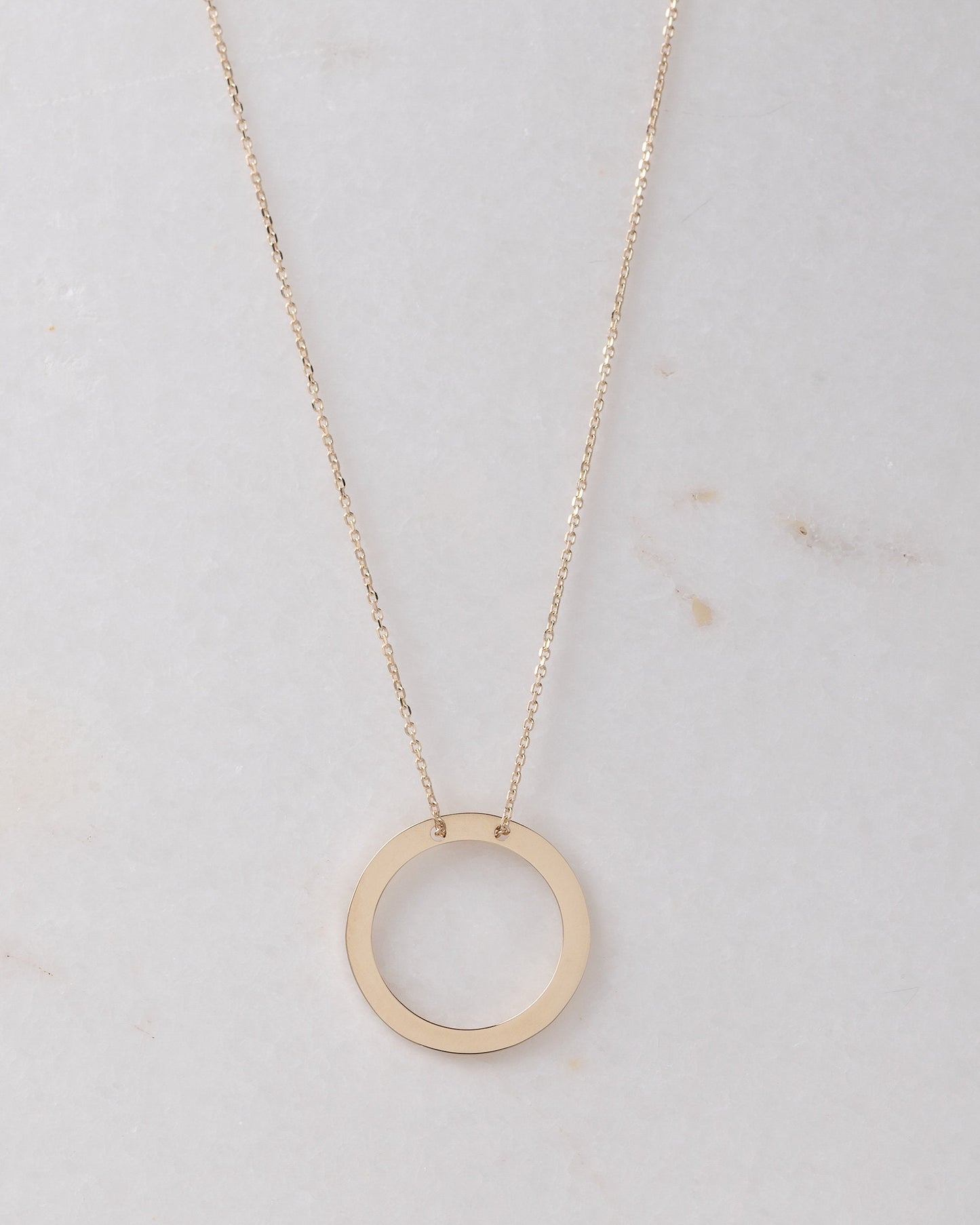 circle karma necklce in 14k gold half of the necklace is paved with cubic zirconia stones