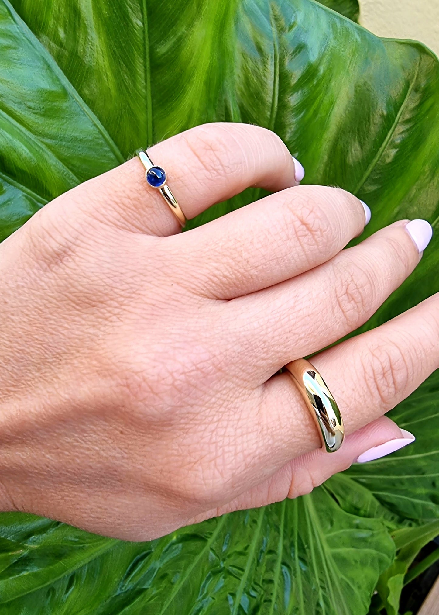 A model wearing a 14k gold dome ring set with a birthstone.