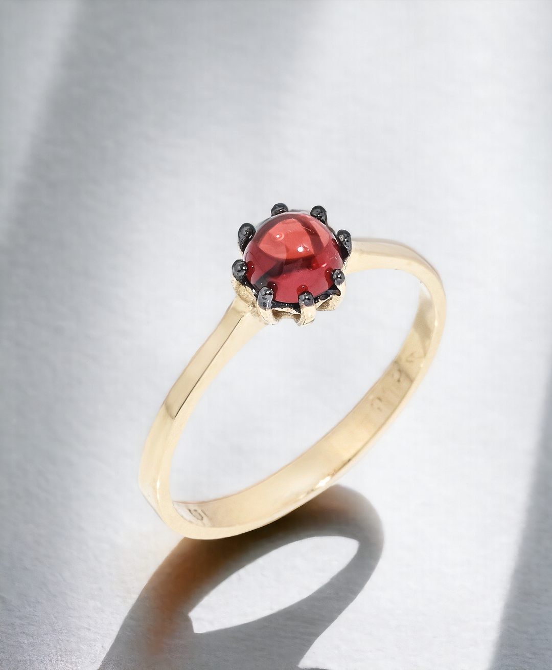 A natural garnet ring set in a 14k solid gold prong setting, designed for women.