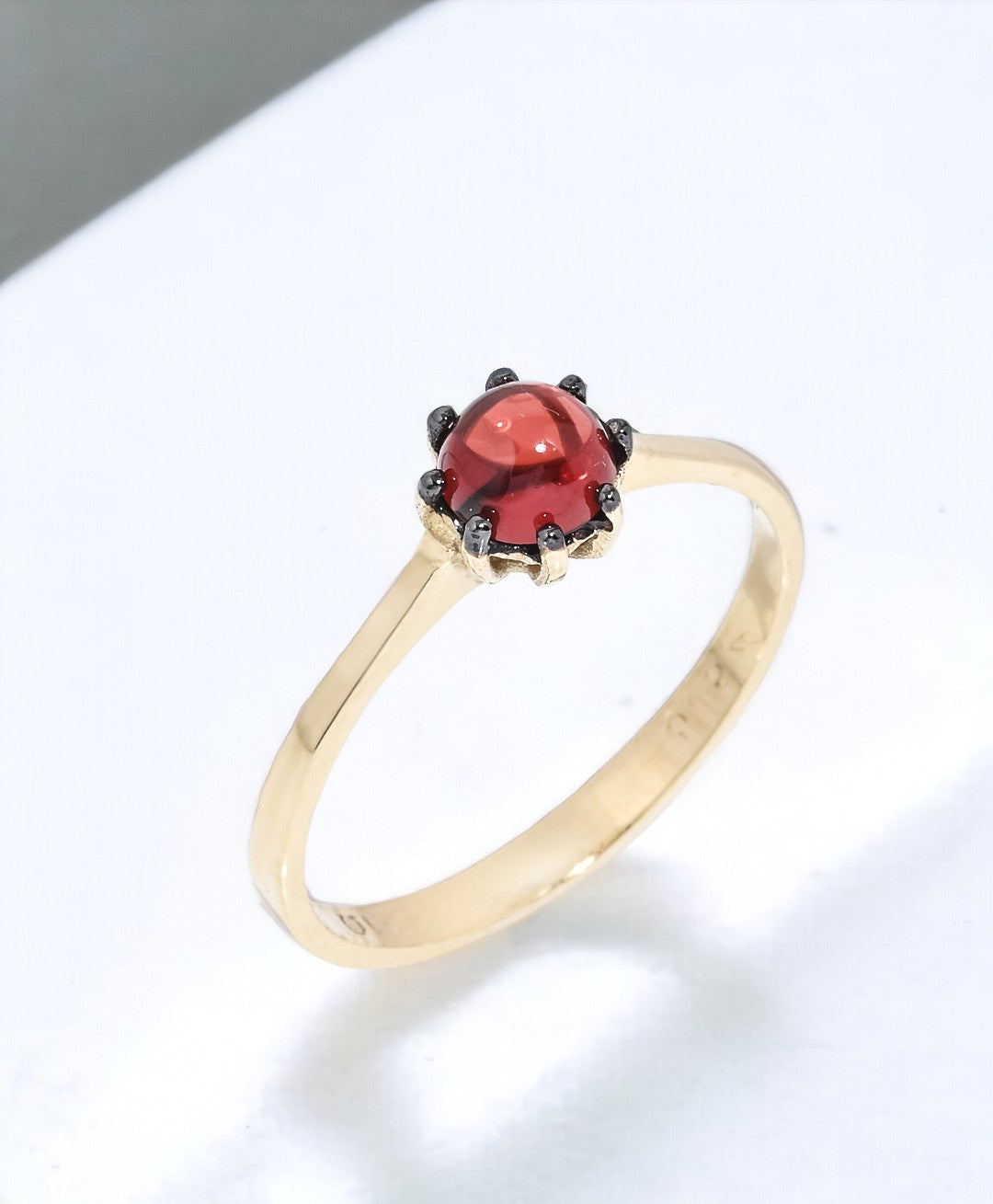 A natural garnet ring set in a 14k solid gold prong setting, designed for women.