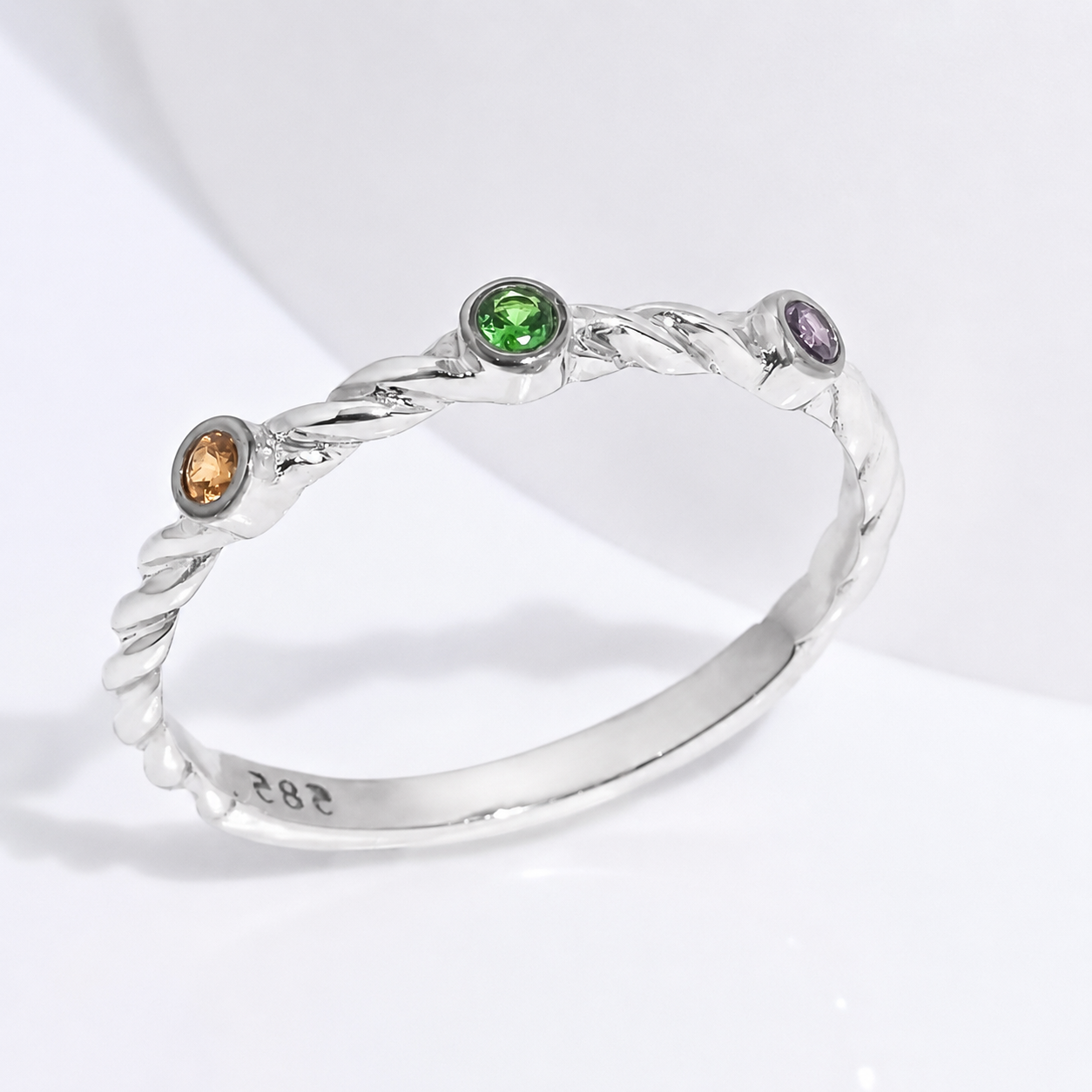14K White Gold ring with three colored gemstones on a white background