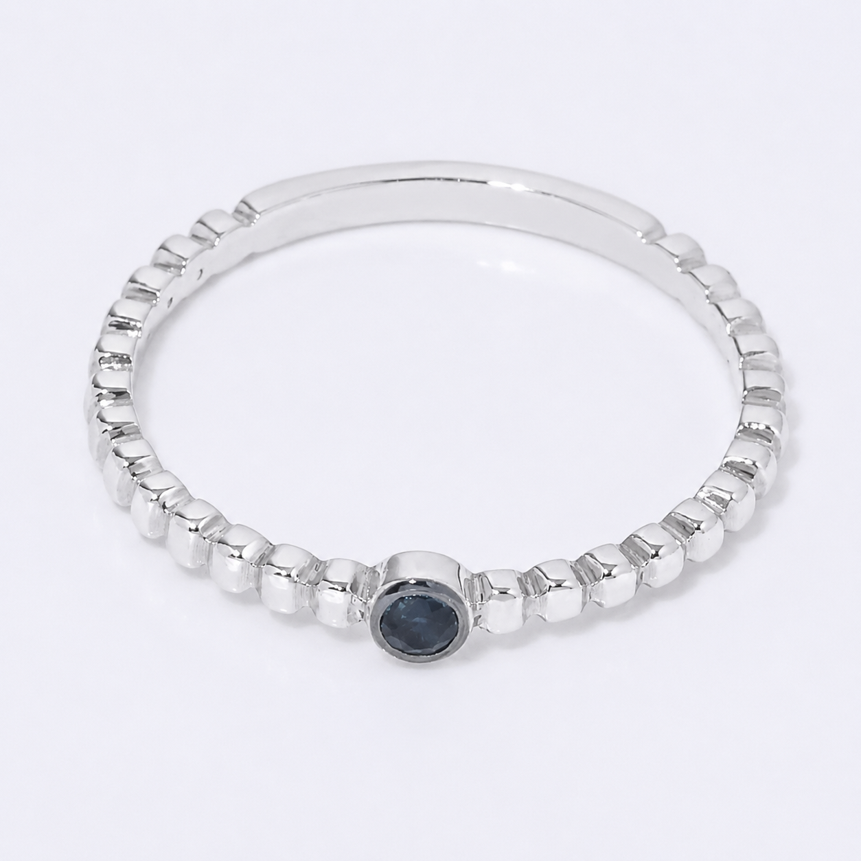 14k white Gold beaded ring with a sapphire gemstone on a white background