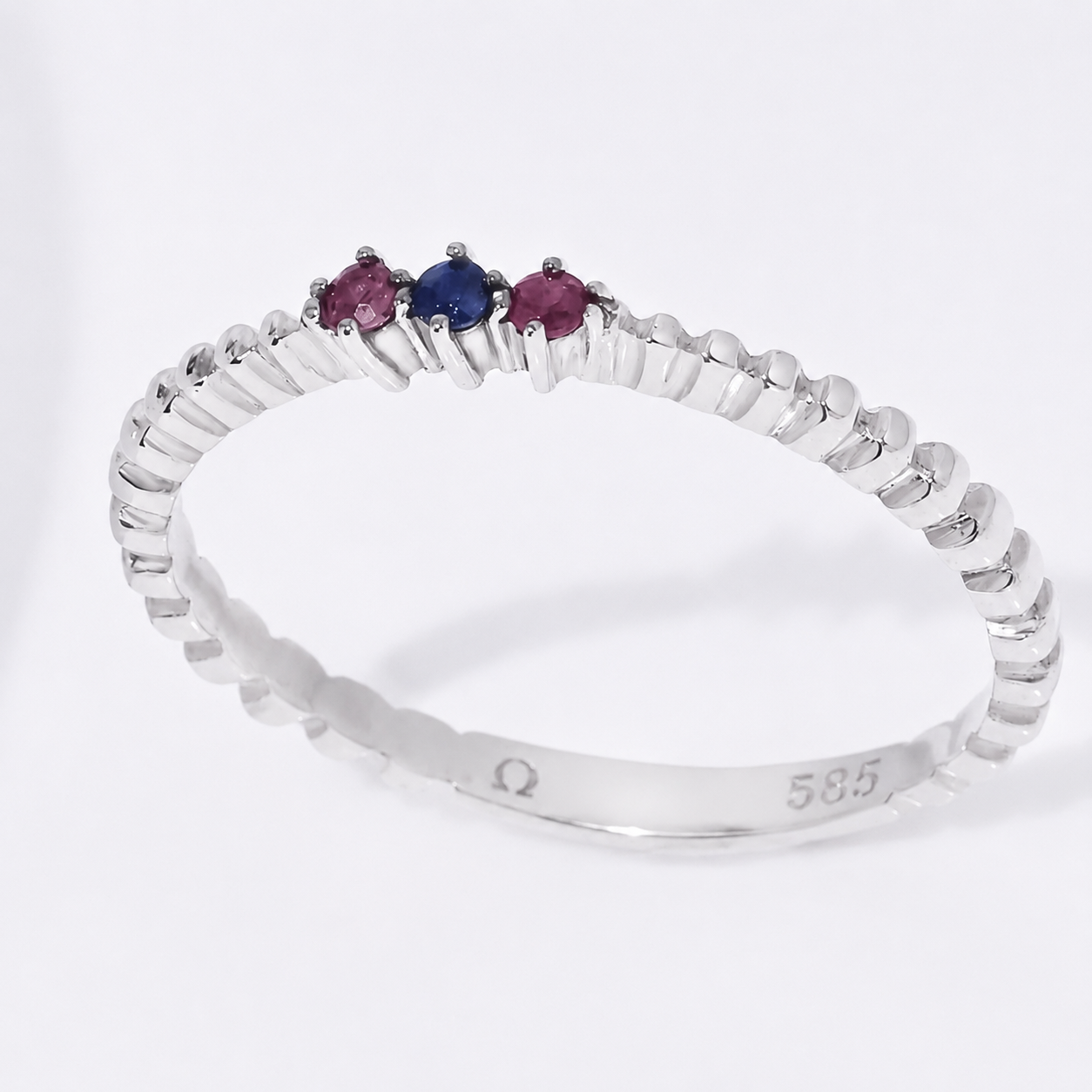 14k white gold ring with three colored gemstones on a white background
