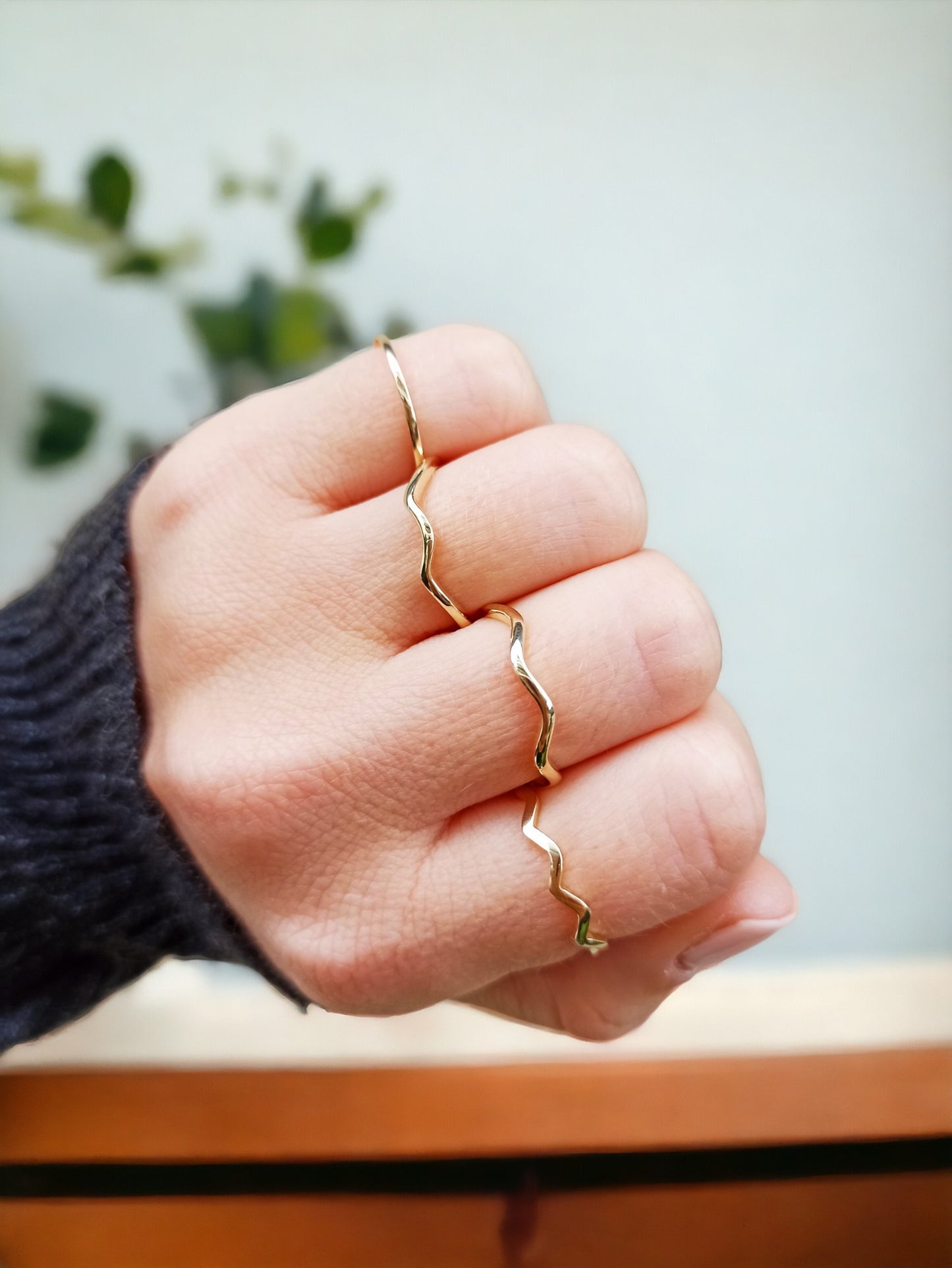 A model is wearing four 14k gold rings with a zigzag design.