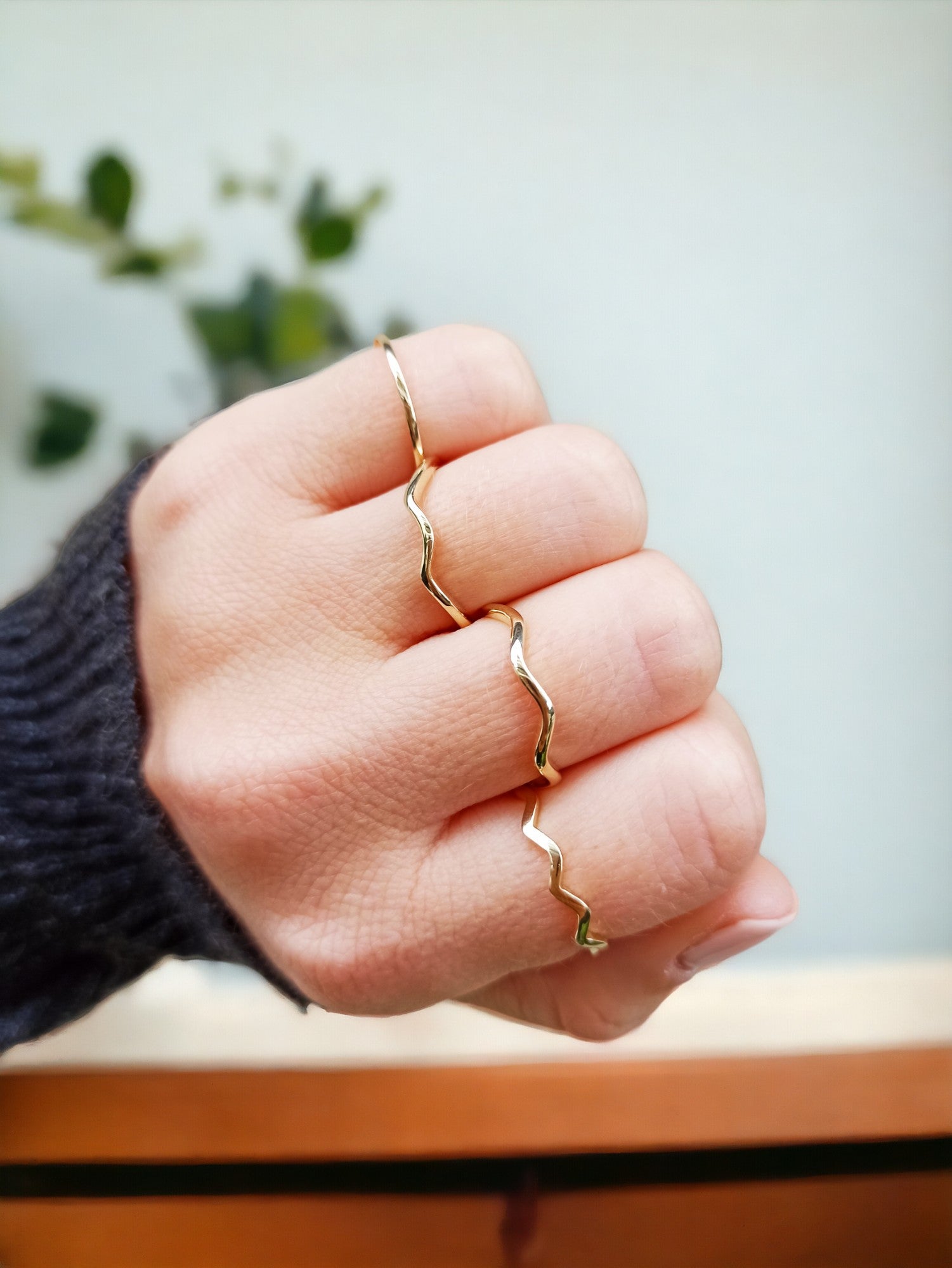 A model is wearing four 14k gold rings with a zigzag design.