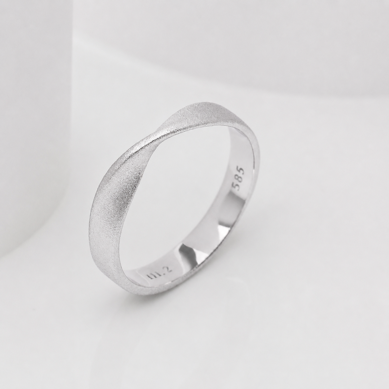 14k Gold mobius ring with a textured band on a white background