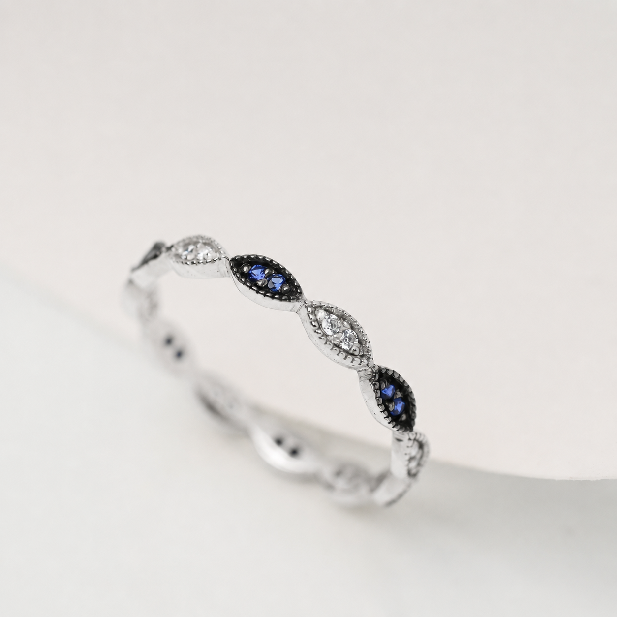 14k white Gold ring with blue and clear gemstones on a white background