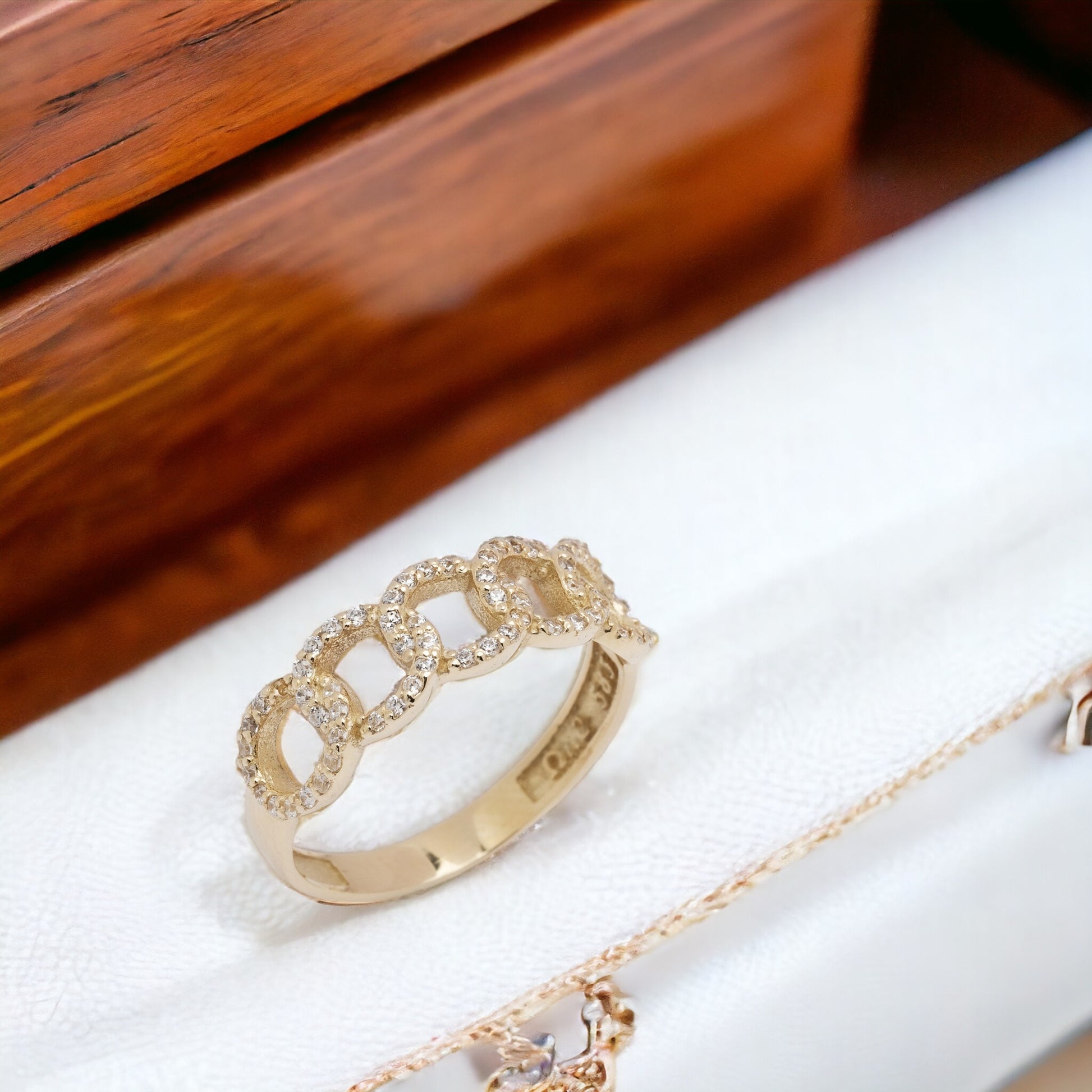 A handmade chain ring crafted in 14k solid gold, embellished with white cubic zirconia stones.