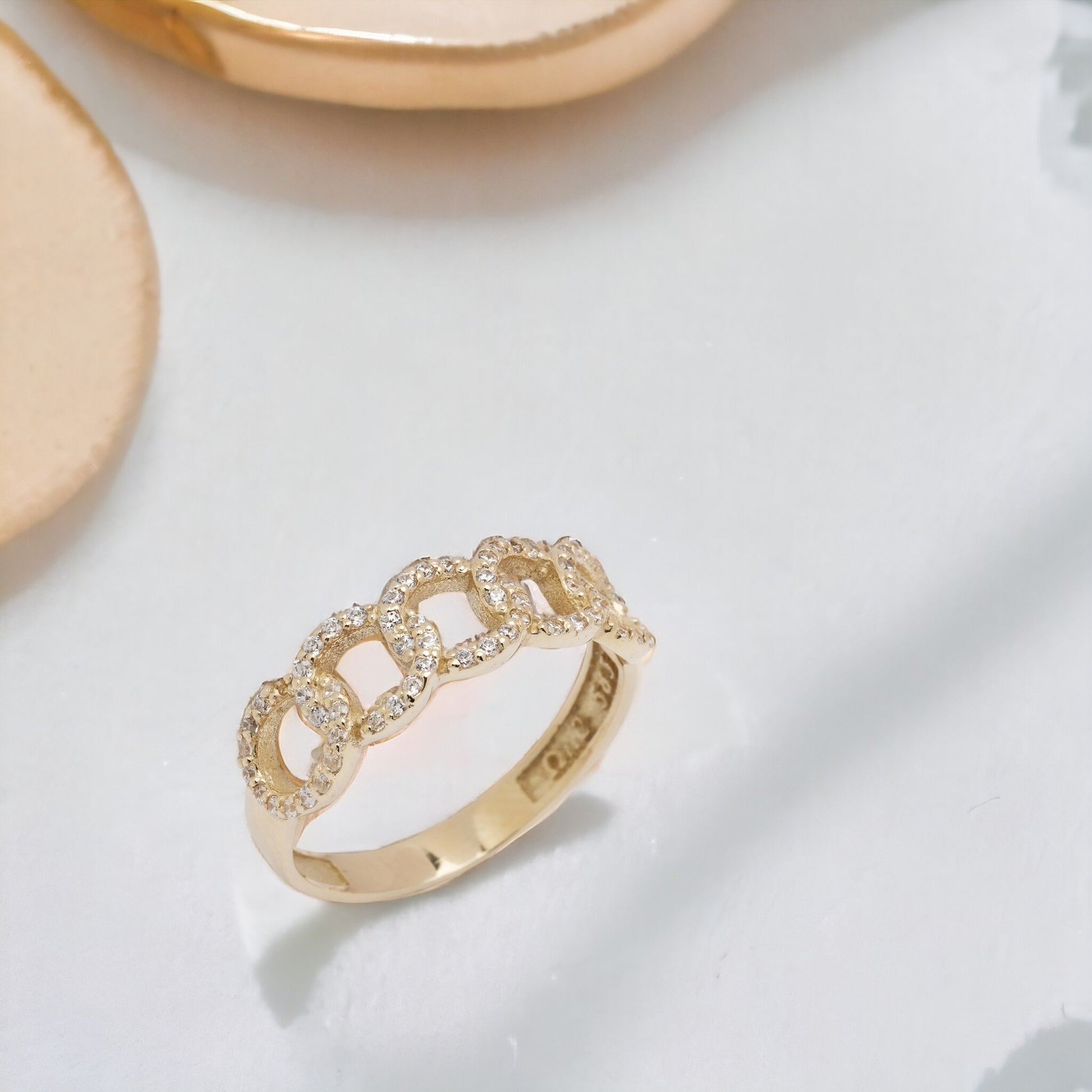 A handmade chain ring crafted in 14k solid gold, embellished with white cubic zirconia stones.