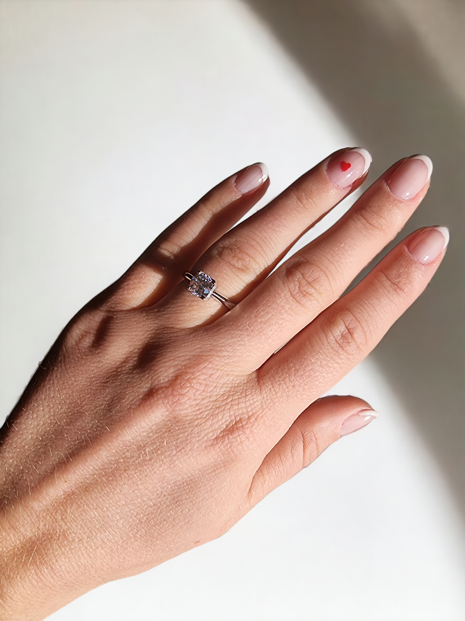 A model wears a round cut engagement ring made of 14k solid gold on her ring finger.