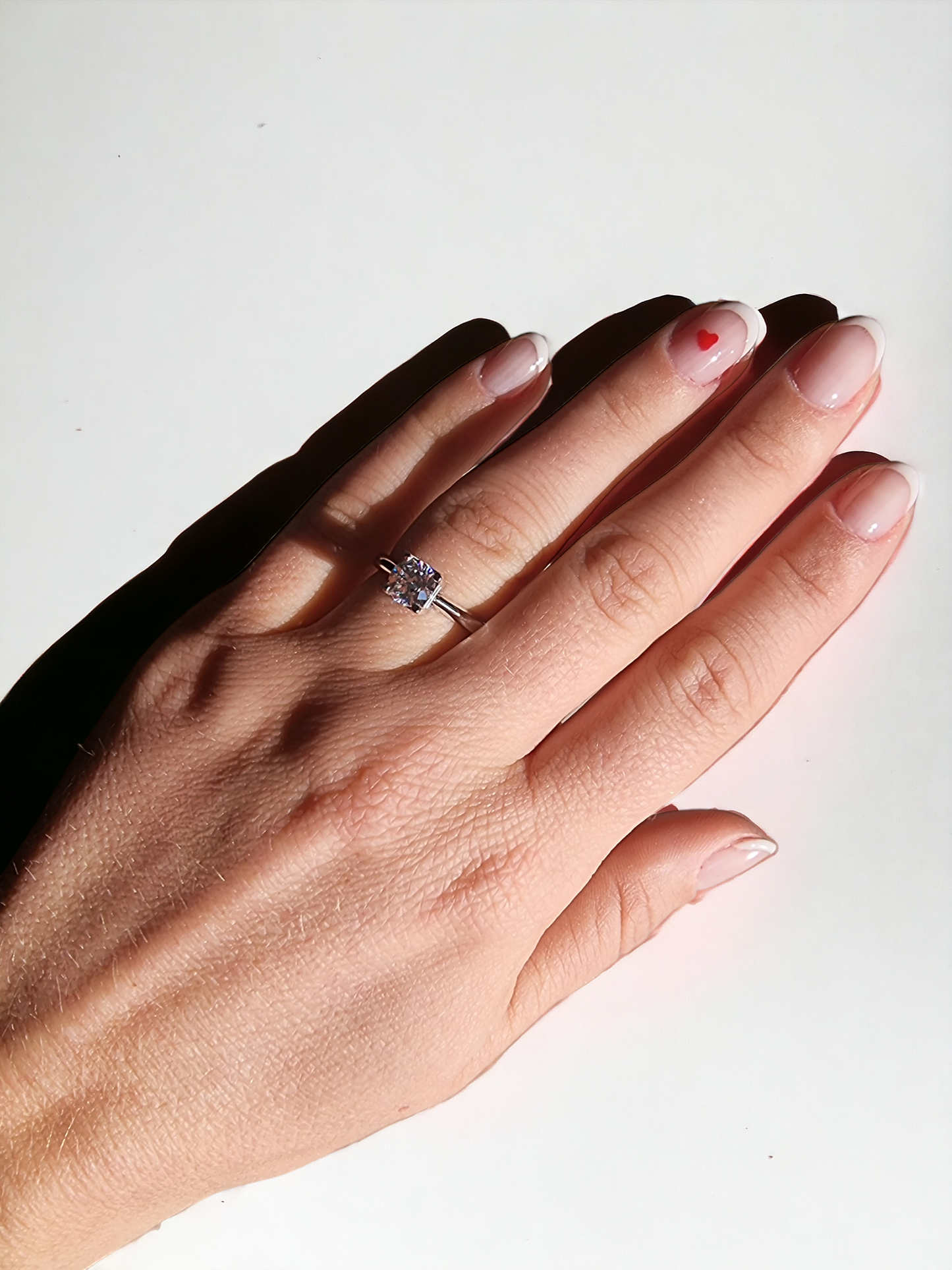 A model wears a round cut engagement ring made of 14k solid gold on her ring finger.