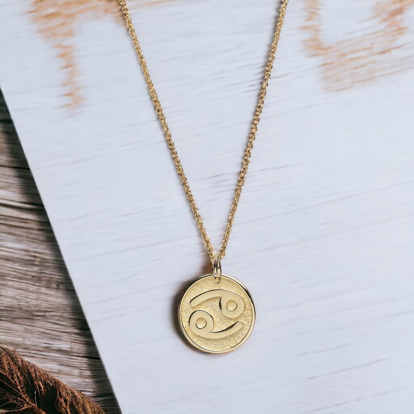 A Zodiac necklace for women, crafted in 14k gold, featuring complimentary engraving on the reverse side.