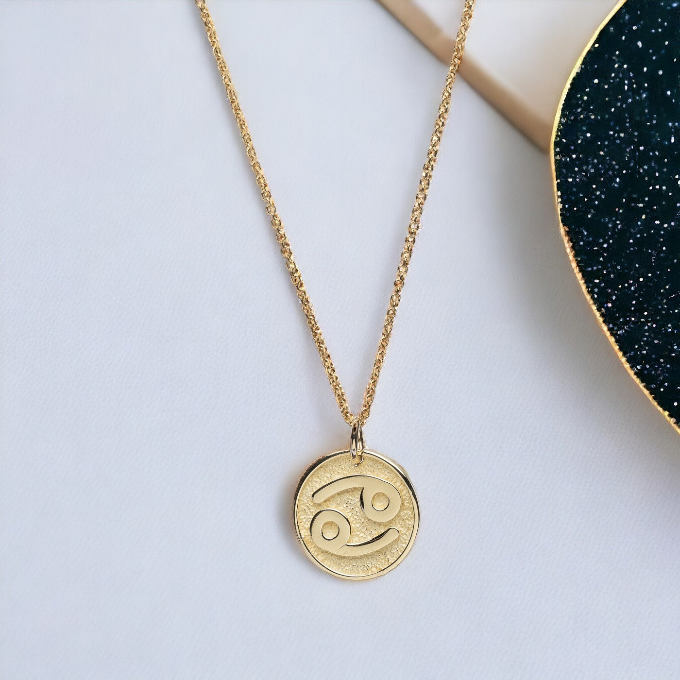 A Zodiac necklace for women, crafted in 14k gold, featuring complimentary engraving on the reverse side.