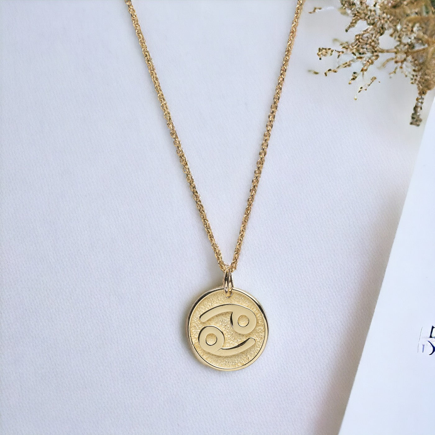 A Zodiac necklace for women, crafted in 14k gold, featuring complimentary engraving on the reverse side.