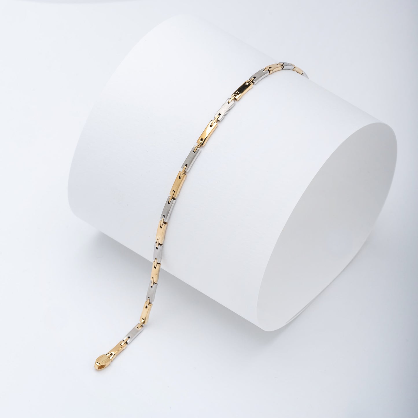 a sleek men's bracelet made of polished metal, yellow-white gold. It features rectangular links connected by smaller rounded connectors, creating a clean, modern design with subtle detailing.