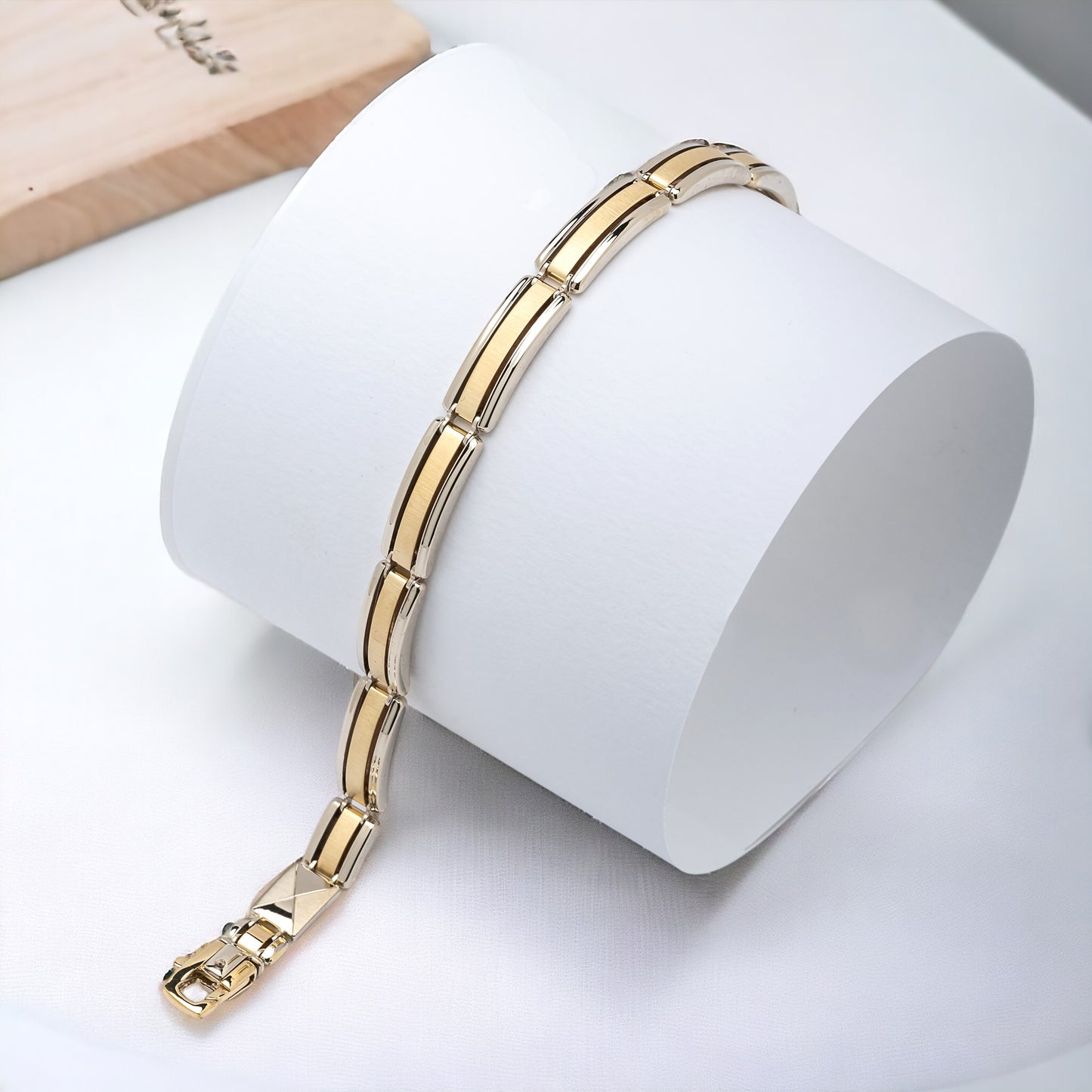 A men's bracelet crafted from yellow and white gold with a bold and structured look. It features wide, rectangular links that are slightly curved, creating a smooth, reflective surface.