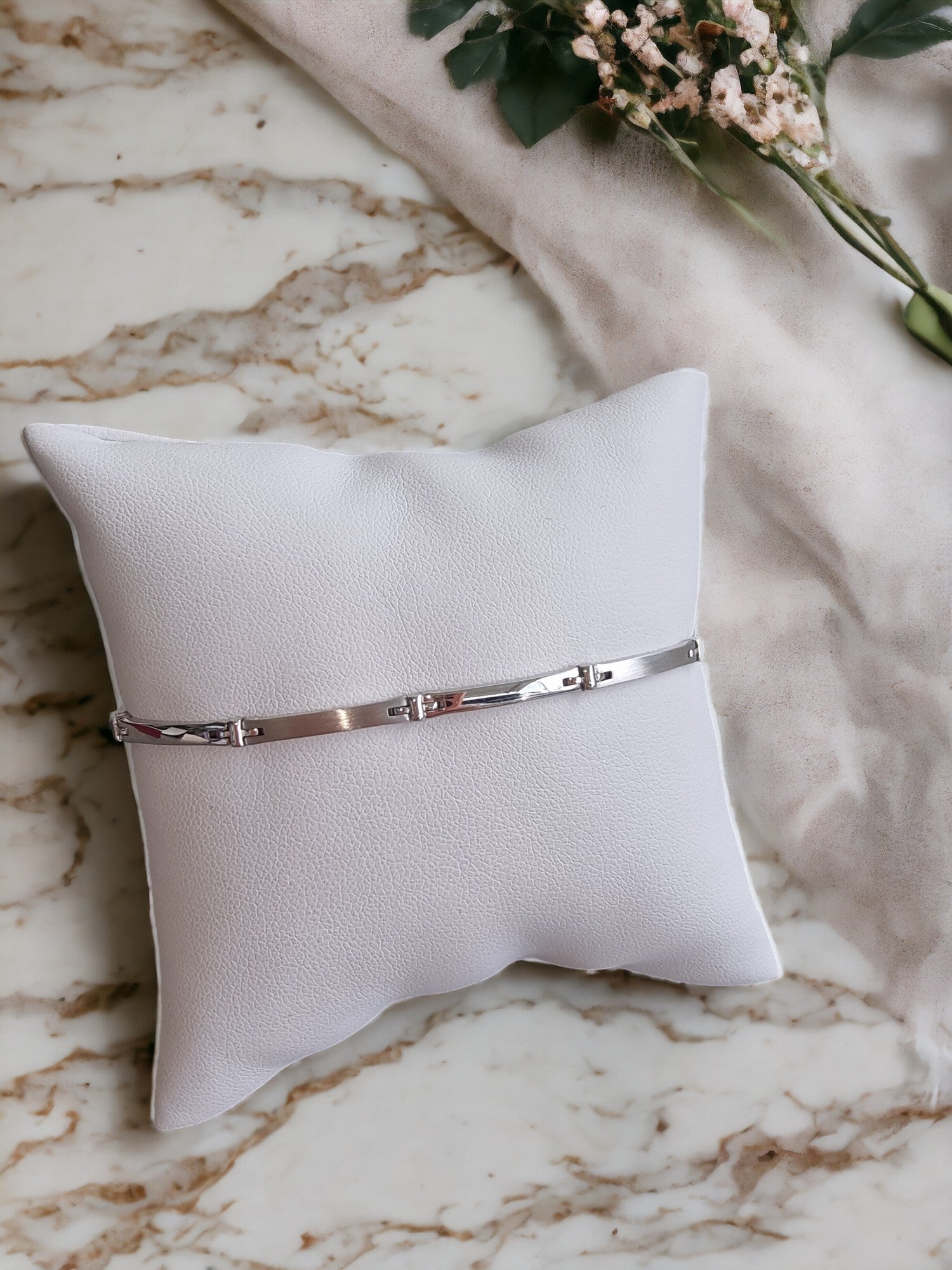 A sleek men's bracelet made of polished white gold. It features rectangular links connected by smaller rounded connectors, creating a clean, modern design with subtle detailing.