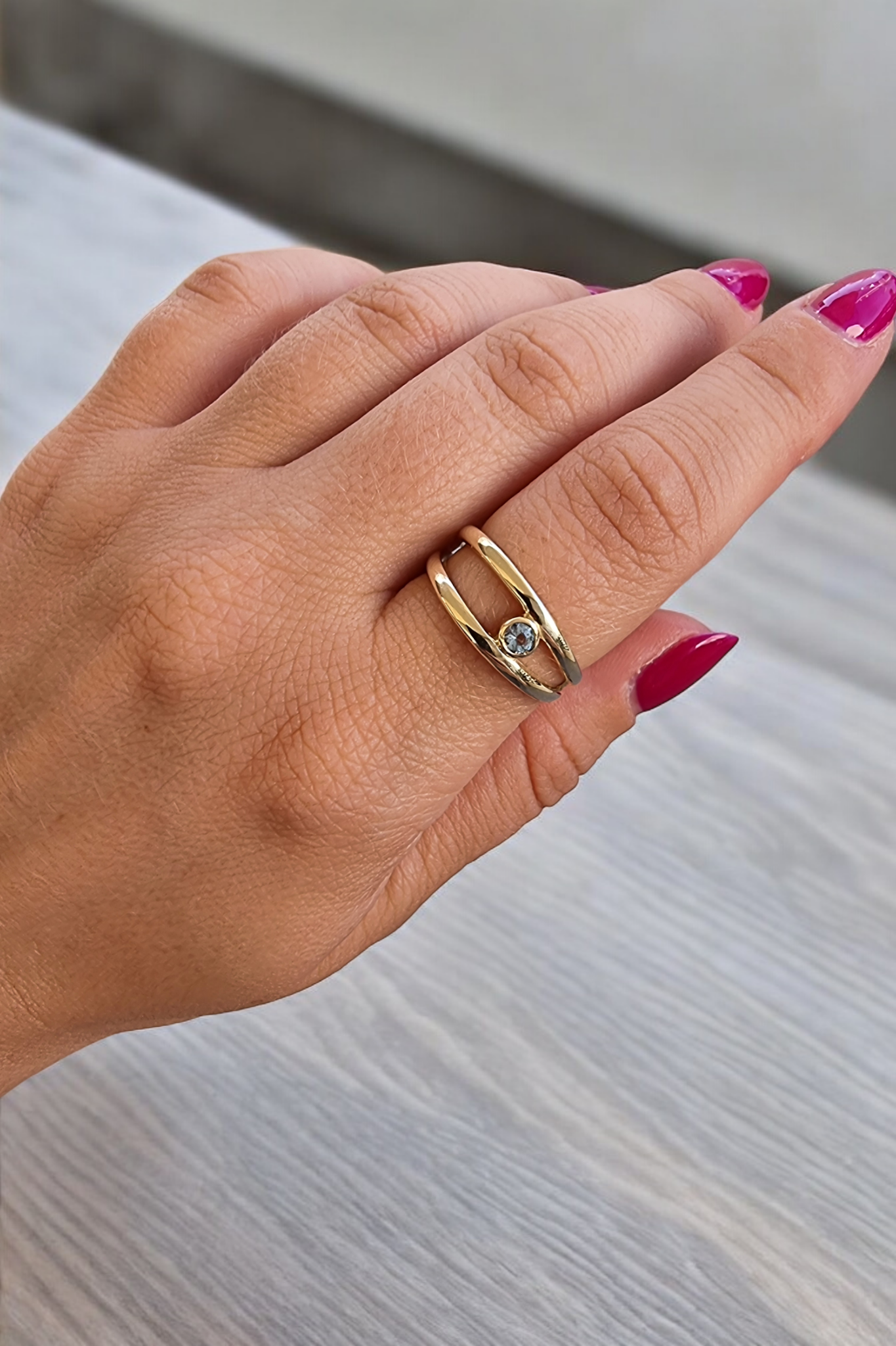 A handmade, double-row birthstone ring set in 14k gold with a bezel setting.