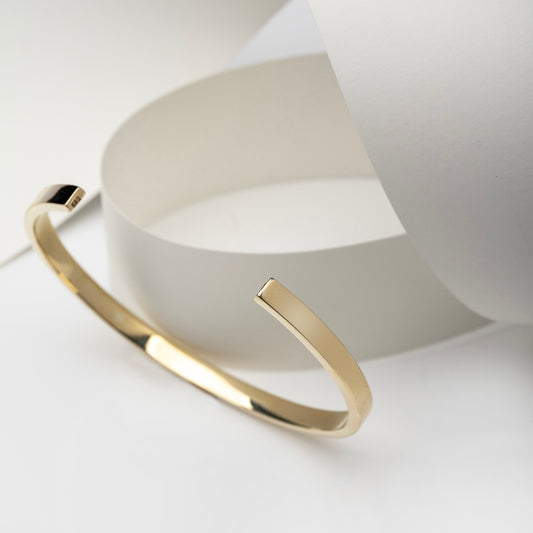 A 4.40mm open cuff bangle bracelet crafted in 14k gold for women.