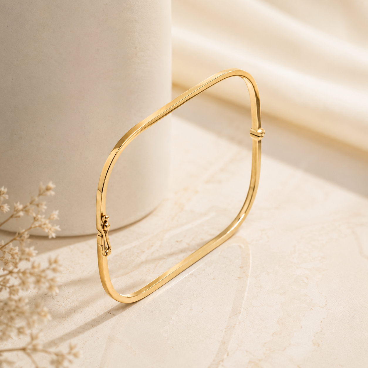 14k Gold square bangle bracelet on a soft beige background with delicate flowers
