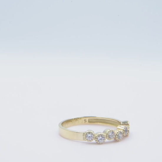 A half-eternity asymmetrical band crafted in 14k solid gold, adorned with white cubic zirconia stones.