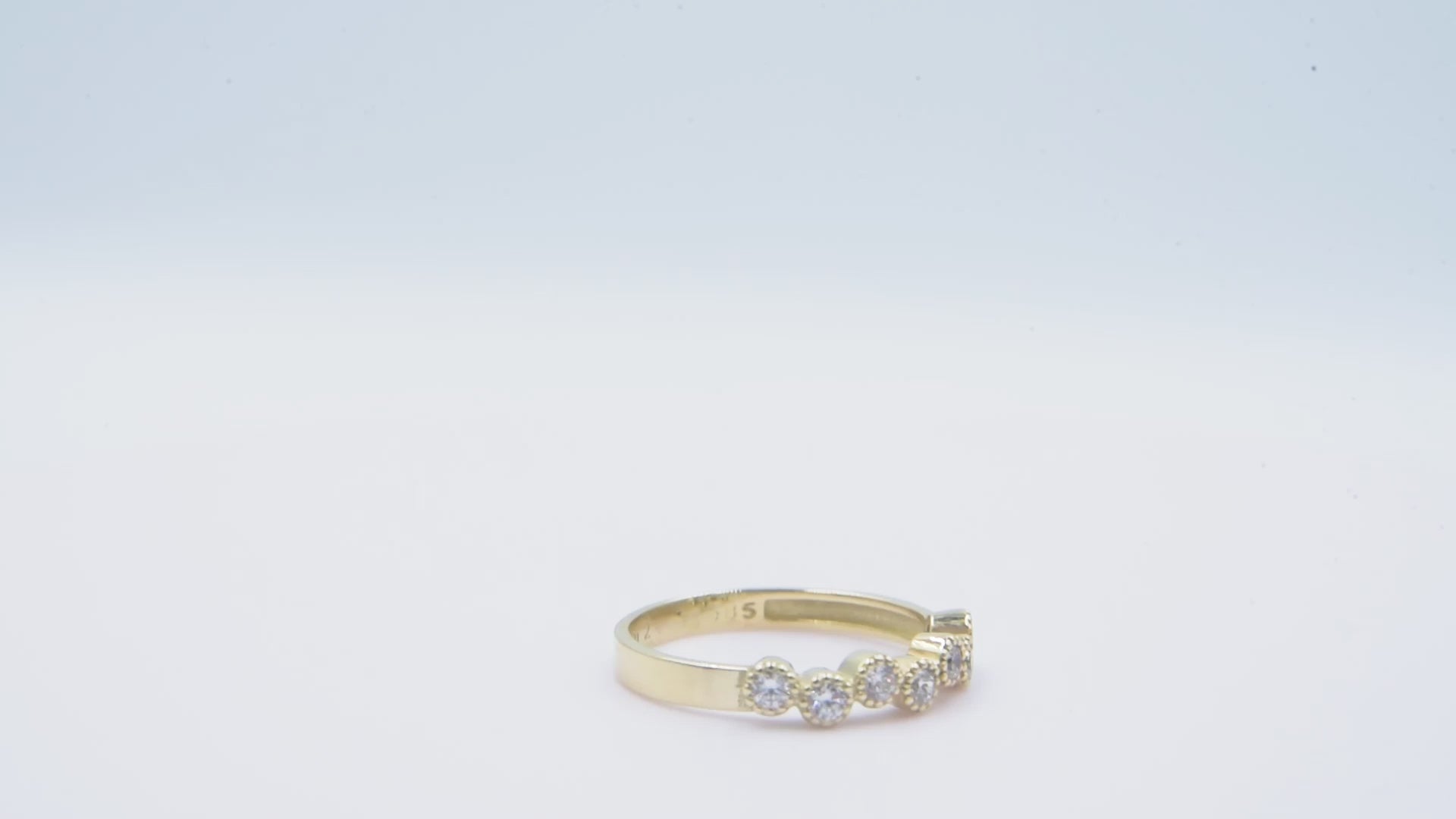 A half-eternity asymmetrical band crafted in 14k solid gold, adorned with white cubic zirconia stones.