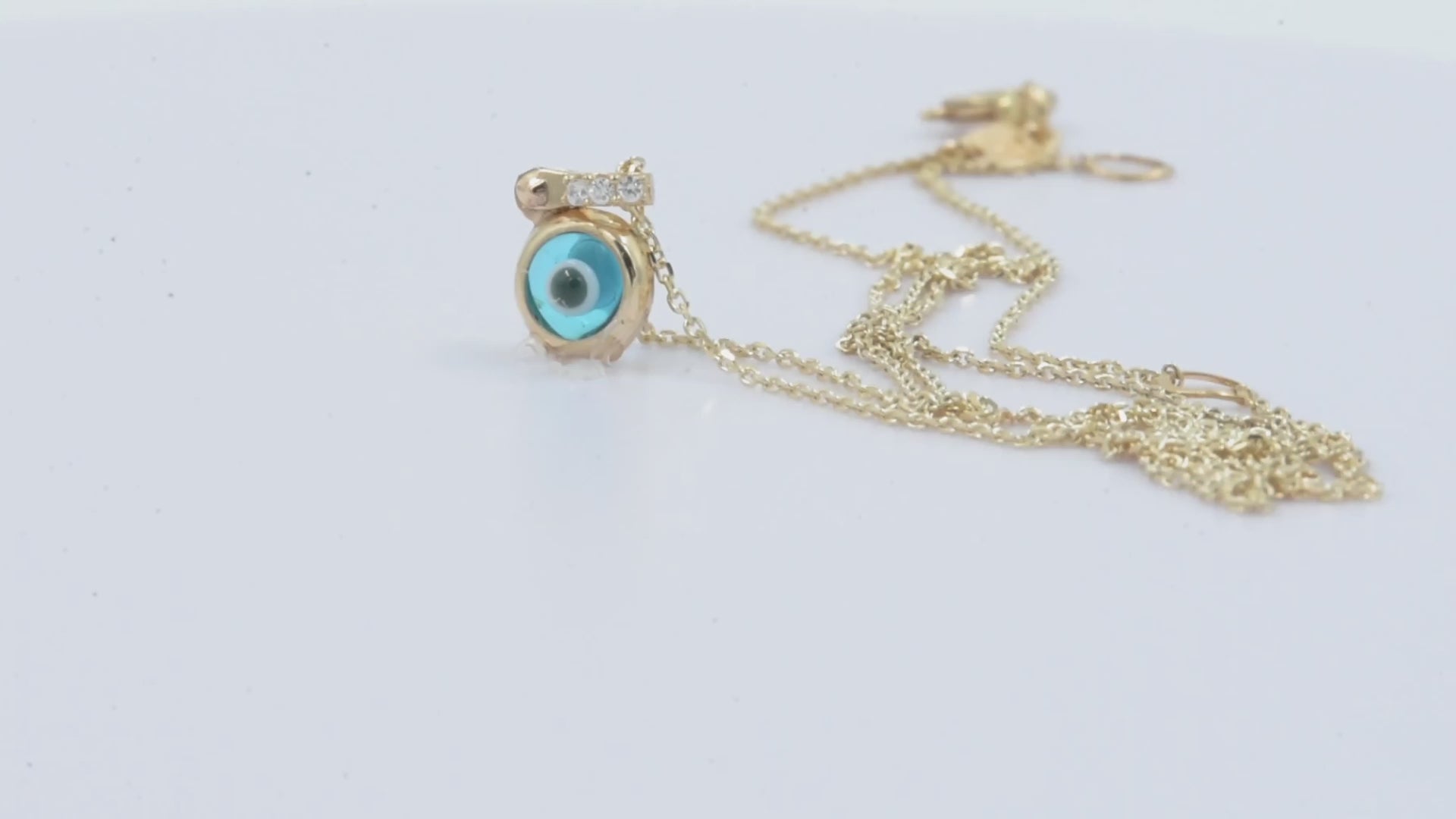 Murano glass evil eye necklace in 14k gold with cubic zirconia stones on the loop for women.