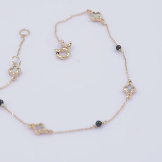 14k gold bracelet with four colver charms and three black onyx beads