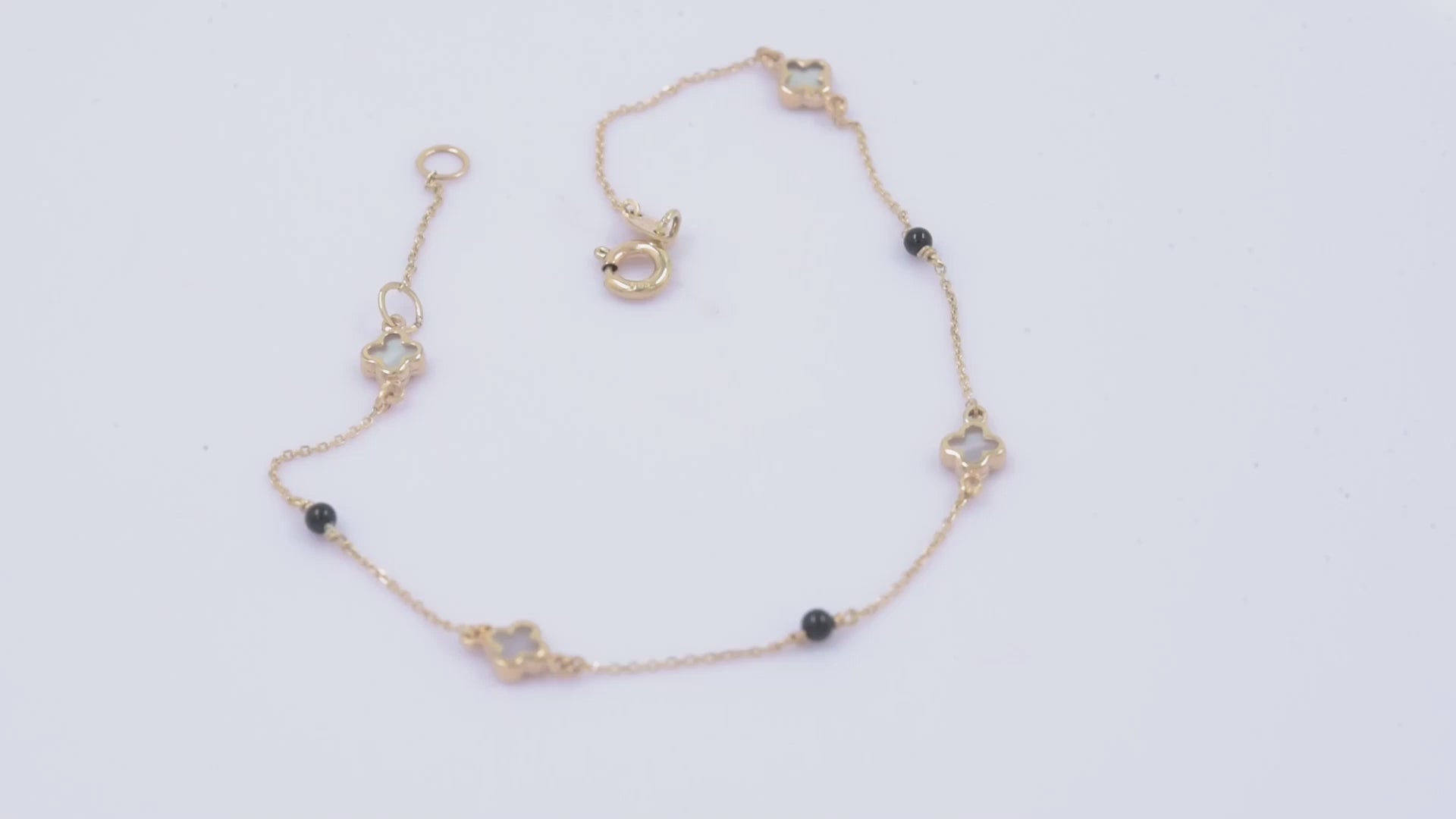 14k gold bracelet with four colver charms and three black onyx beads