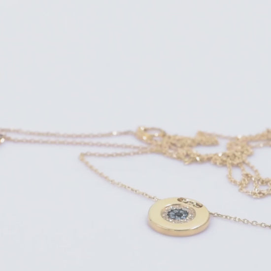 A women's round evil eye necklace, encrusted with cubic zirconia stones and crafted in 14k gold.