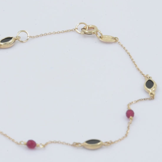 a 14k gold station bracelet with onyx and tourmaline