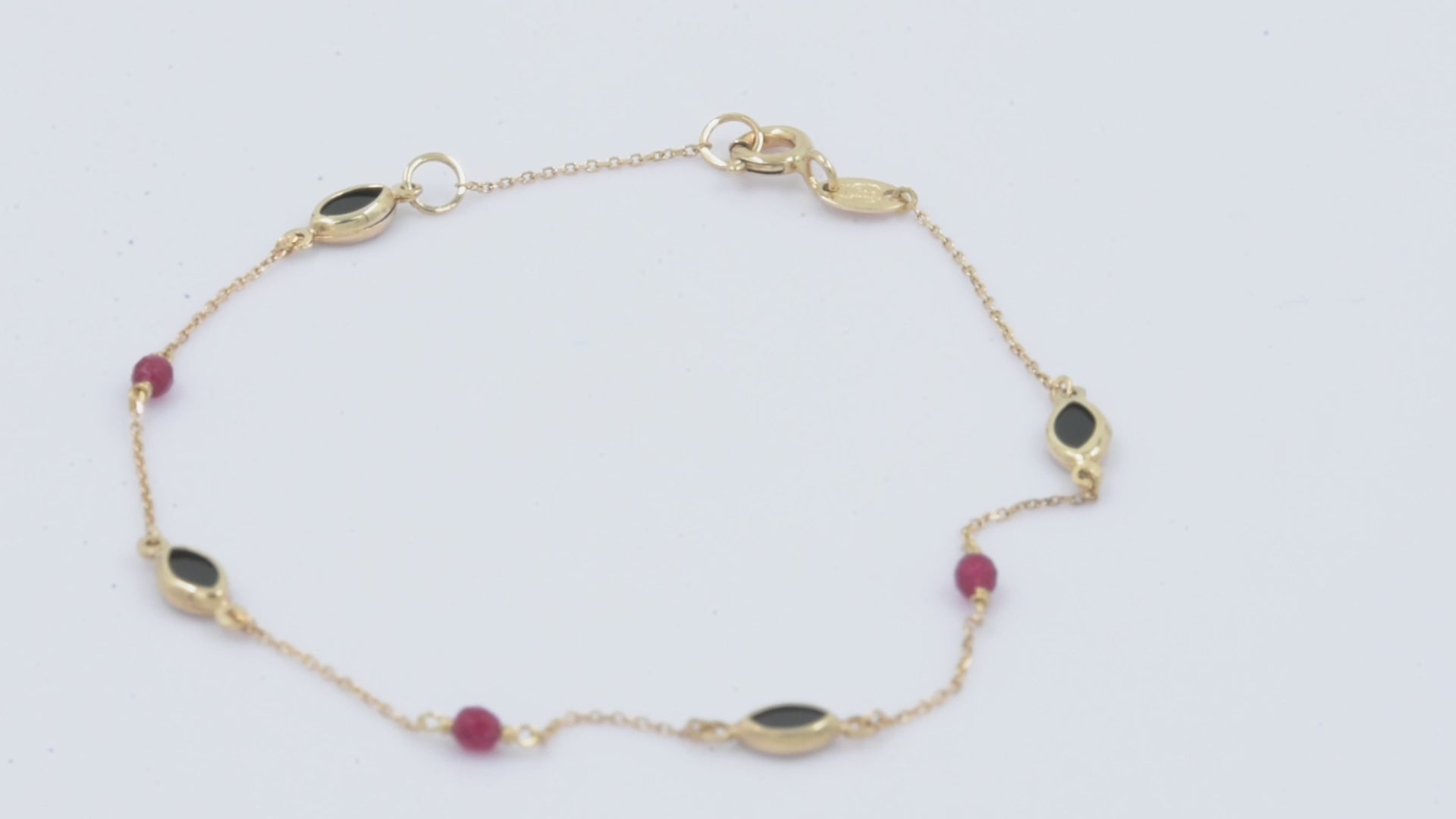 a 14k gold station bracelet with onyx and tourmaline