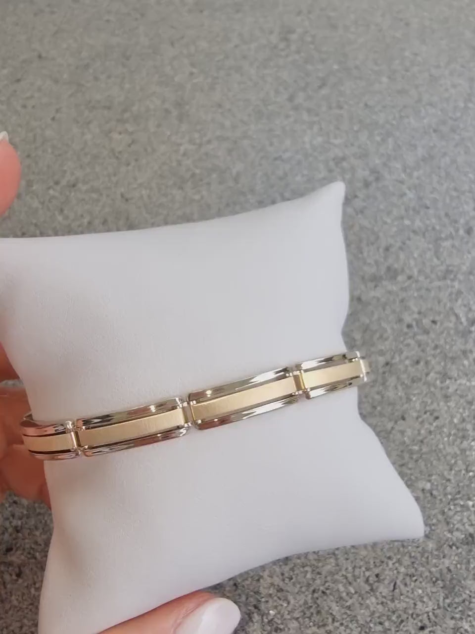 A men's bracelet crafted from yellow and white gold with a bold and structured look. It features wide, rectangular links that are slightly curved, creating a smooth, reflective surface.