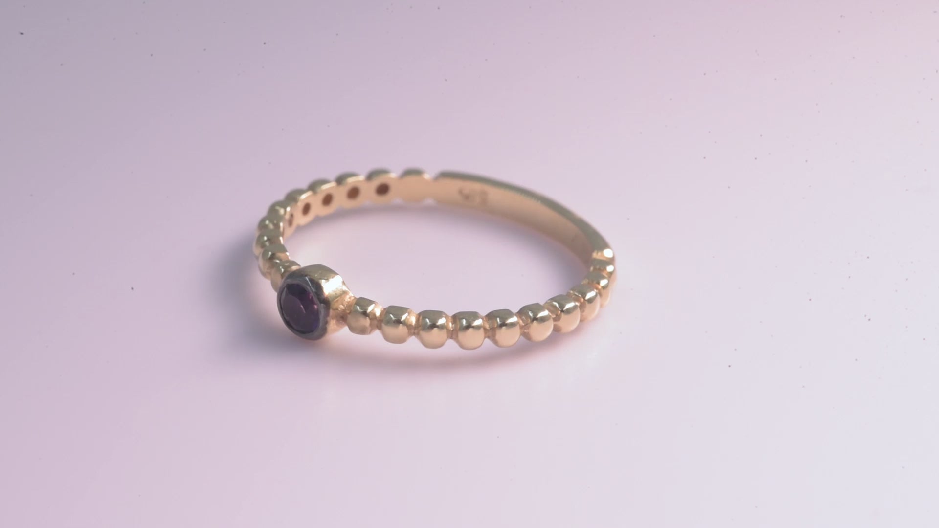 A beaded ring featuring a sapphire birthstone set in 14k gold.