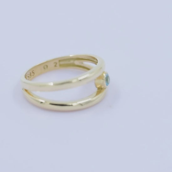 A handmade, double-row birthstone ring set in 14k gold with a bezel setting.