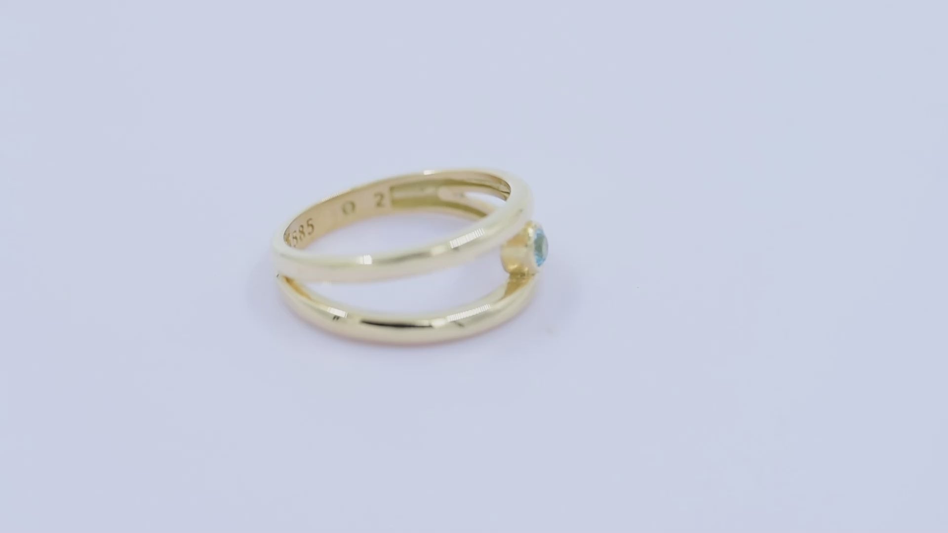 A handmade, double-row birthstone ring set in 14k gold with a bezel setting.