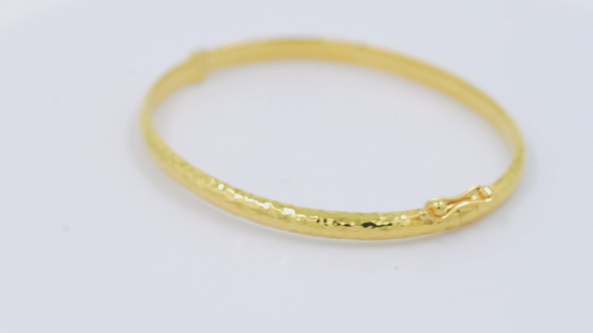 A 4.20mm hammered bangle bracelet in 14k gold, designed for women to adorn their wrist.