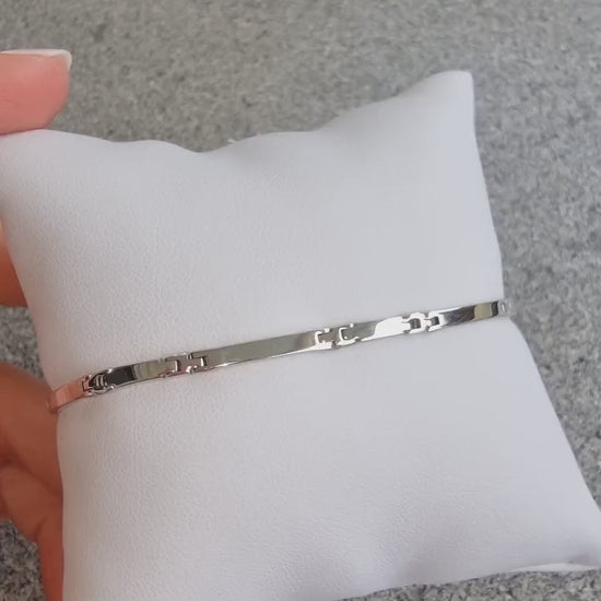 A sleek men's bracelet made of polished white gold. It features rectangular links connected by smaller rounded connectors, creating a clean, modern design with subtle detailing.