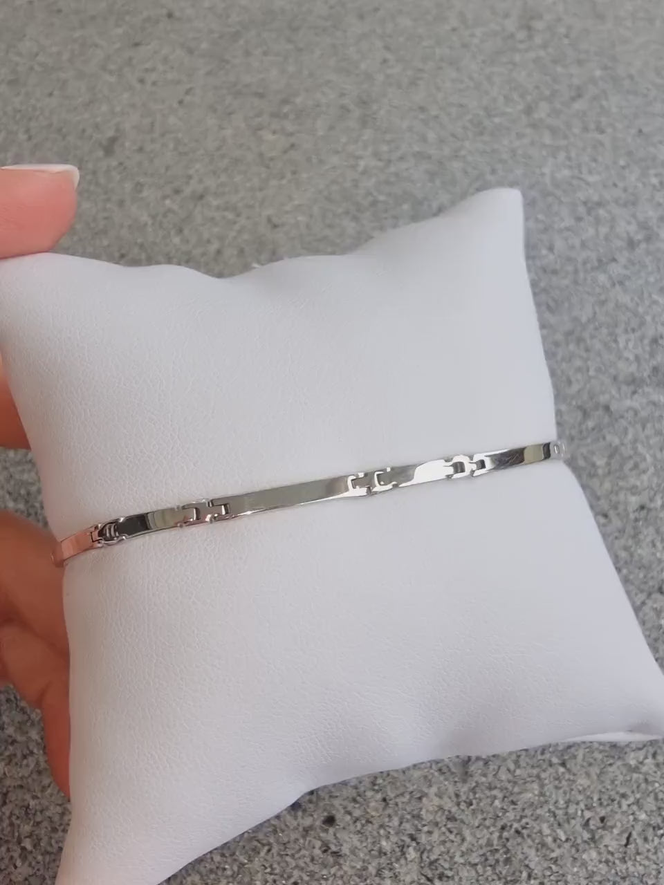 A sleek men's bracelet made of polished white gold. It features rectangular links connected by smaller rounded connectors, creating a clean, modern design with subtle detailing.