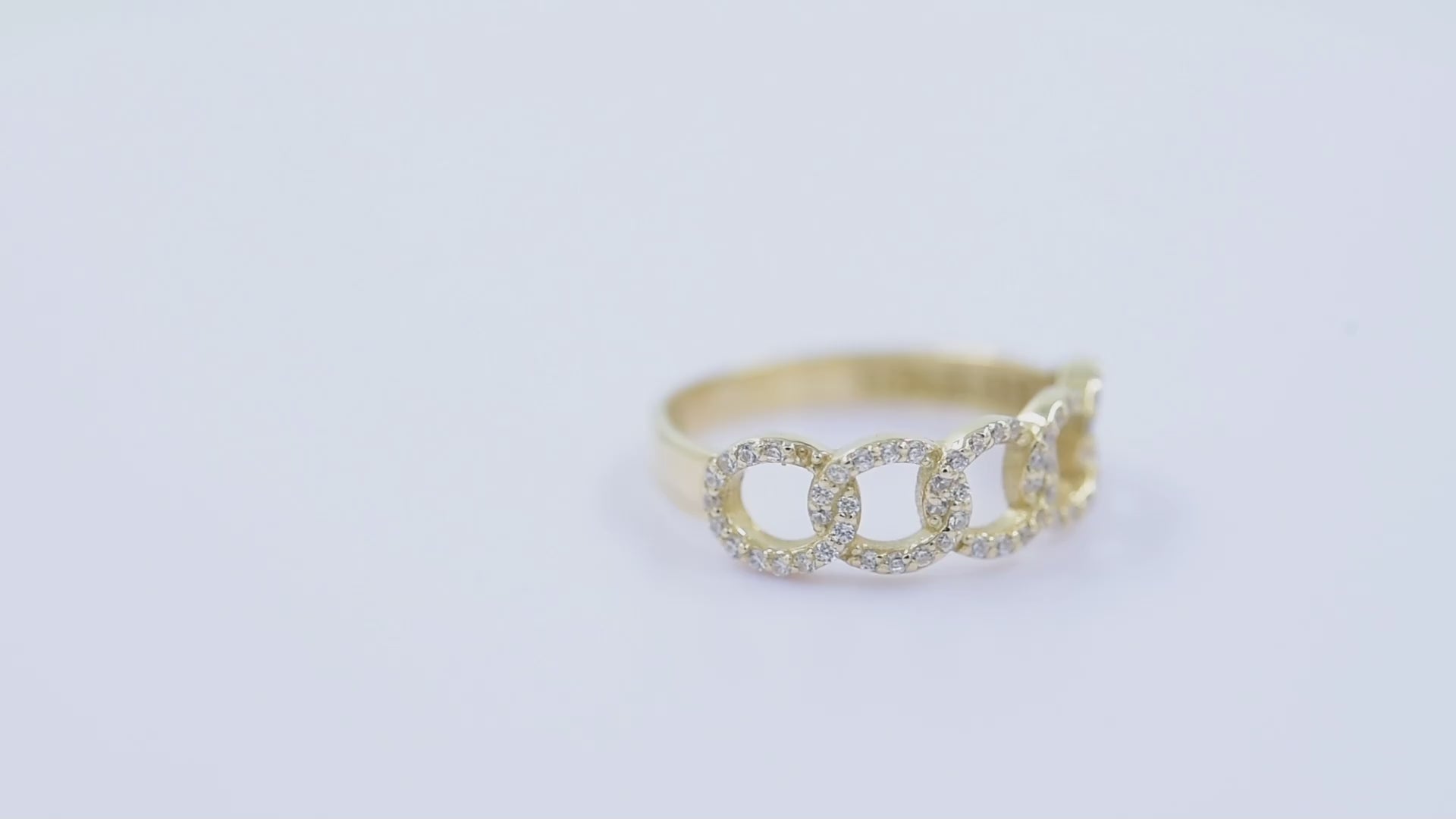 A handmade chain ring crafted in 14k solid gold, embellished with white cubic zirconia stones.