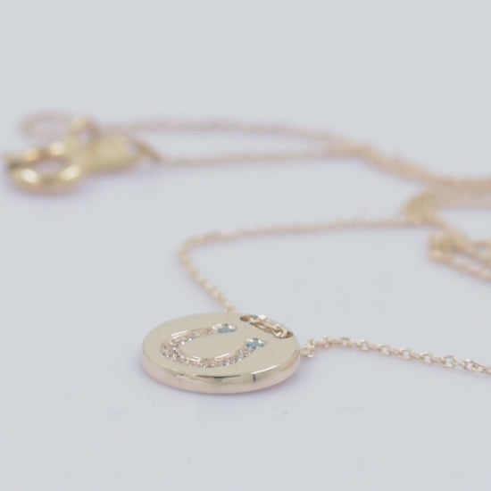 coin necklace in 14k gold with paved horseshoe