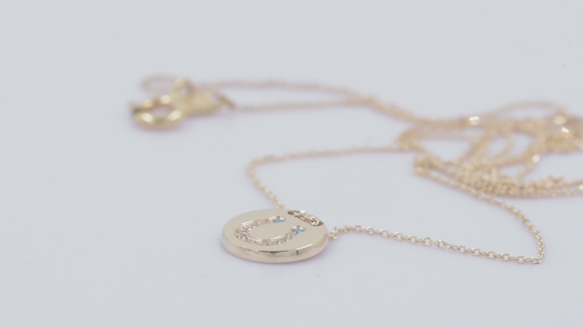 coin necklace in 14k gold with paved horseshoe